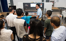 Family members watching a machine demonstration with great interest