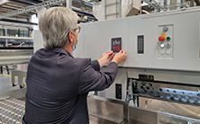 Head of Marketing Frank Mayer attaches the anniversary plaque to a cutting machine 